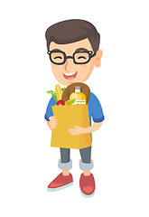 Image showing Boy holding paper shopping bag full of groceries.
