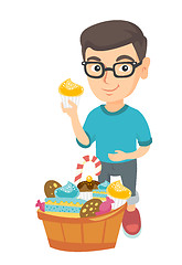 Image showing Boy holding a cupcake and stroking his belly.