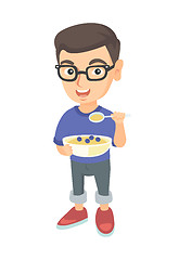 Image showing Happy boy holding a spoon and bowl of porridge.
