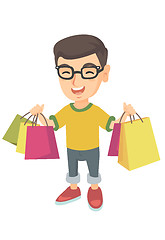 Image showing Happy caucasian boy holding shopping bags.