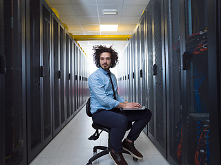 Image showing engineer working on a laptop in server room