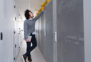 Image showing IT engineer working on a tablet computer in server room