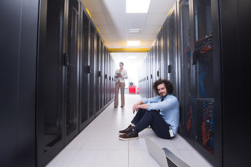 Image showing Team of young technicians working together on servers