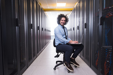 Image showing engineer working on a laptop in server room