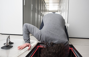 Image showing engineer connecting cables in server room