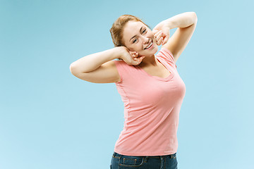 Image showing The happy business woman standing and smiling against pastel background.