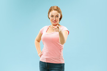 Image showing The happy business woman point you and want you, half length closeup portrait on blue background.