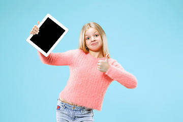 Image showing Little funny girl with tablet on blue background