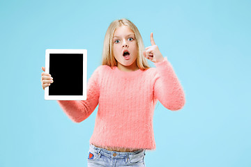 Image showing Little funny girl with tablet on blue background