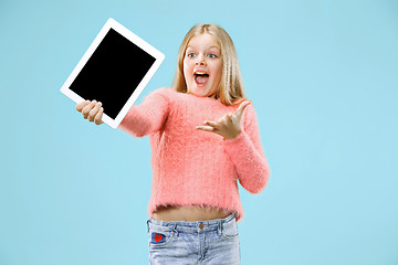 Image showing Little funny girl with tablet on blue background