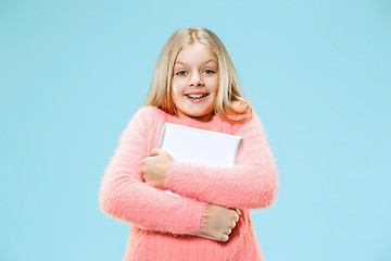 Image showing Teen girl with laptop. Love to computer concept. Attractive female half-length front portrait, trendy blue studio backgroud.