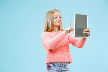 Image showing Teen girl with laptop. Love to computer concept. Attractive female half-length front portrait, trendy blue studio backgroud.