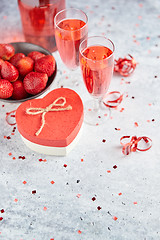 Image showing Bottle of rose champagne, glasses with fresh strawberries and heart shaped gift