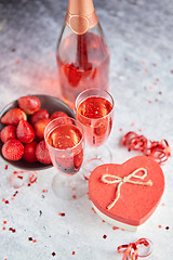 Image showing Bottle of rose champagne, glasses with fresh strawberries and he