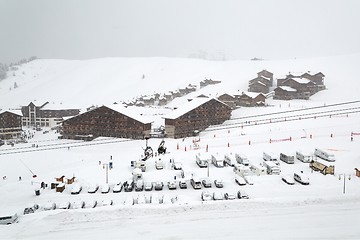 Image showing Snowy mountain skiing village, falling snow