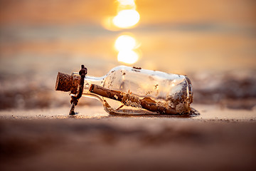 Image showing Message in the bottle against the Sun setting down