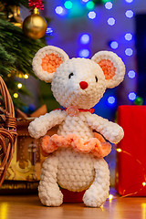 Image showing Knitted toy white mouse in a sunface under a Christmas tree