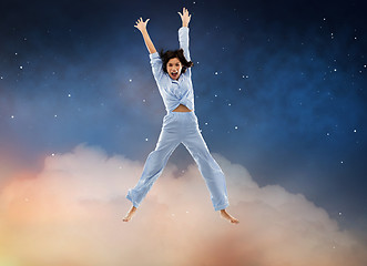 Image showing happy woman in blue pajama jumping high