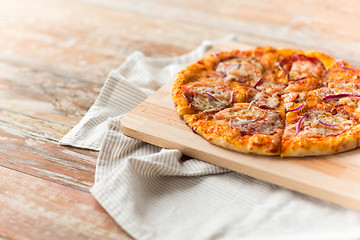 Image showing close up of homemade pizza on wooden table