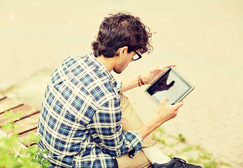 Image showing man with tablet pc sitting on city street bench