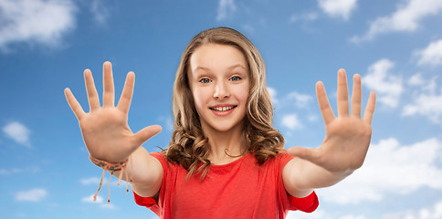 Image showing happy teenage girl giving high five over sky