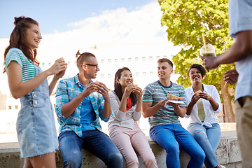 Image showing friends eating sandwiches or burgers in park