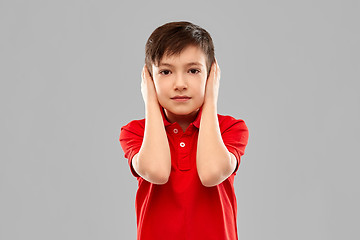 Image showing boy in red t-shirt closing ears by hands