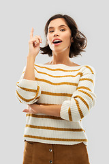 Image showing woman in striped pullover pointing her finger up