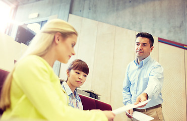 Image showing teacher giving exam tests to students at lecture