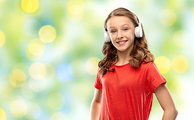 Image showing happy teenage girl in headphones over green lights