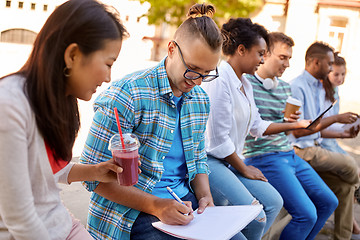 Image showing group of happy students with notebook and drinks