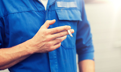 Image showing close up of auto mechanic smoking cigarette