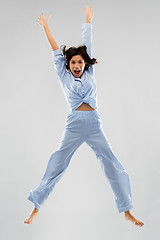 Image showing happy woman in blue pajama jumping high