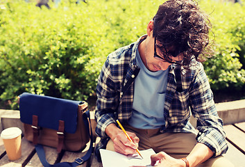 Image showing man with notebook or diary writing on city street