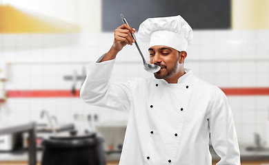 Image showing happy indian chef tasting food by ladle at kitchen