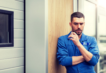 Image showing auto mechanic smoking cigarette at car workshop