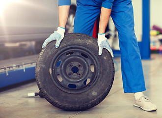 Image showing mechanic with wheel tire at car workshop