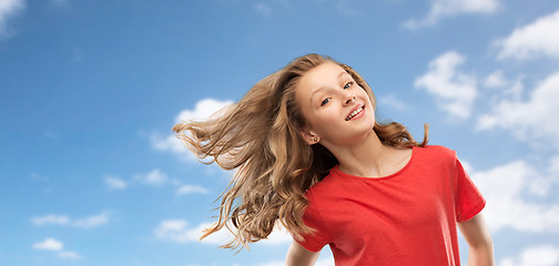 Image showing smiling teenage girl in red with long wavy hair