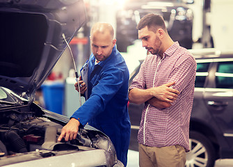 Image showing auto mechanic with clipboard and man at car shop