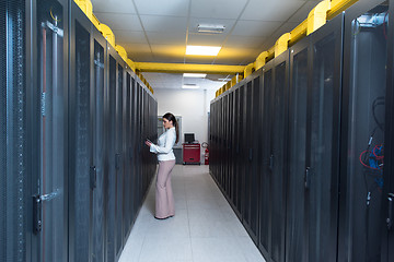 Image showing Female engineer working on a tablet computer in server room