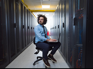 Image showing engineer working on a laptop in server room