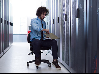 Image showing engineer working on a laptop in server room