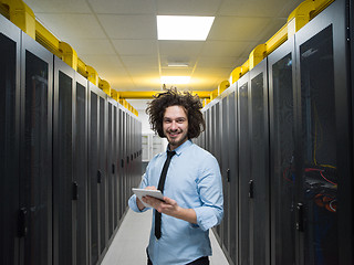 Image showing IT engineer working on a tablet computer in server room