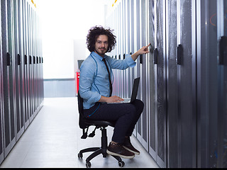 Image showing engineer working on a laptop in server room