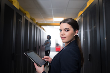 Image showing Female engineer working on a tablet computer in server room