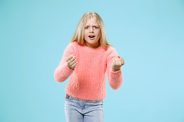 Image showing Portrait of angry teen girl on a blue studio background