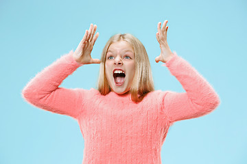 Image showing Isolated on blue young casual teen girl shouting at studio