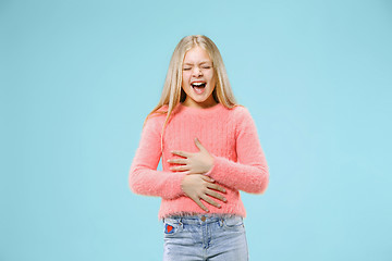 Image showing The happy teen girl standing and smiling against blue background.