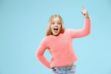 Image showing Beautiful teen girl looking suprised isolated on blue