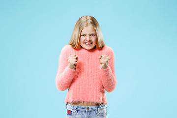 Image showing Portrait of angry teen girl on a blue studio background